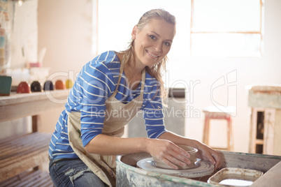 Beautiful female potter making pot