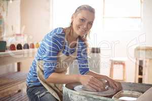 Beautiful female potter making pot