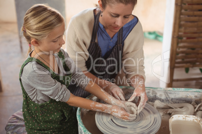 Female potter assisting girl