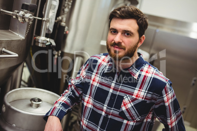 Confident manufacturer standing in brewery