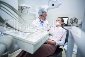 Smiling dentist talking to patient