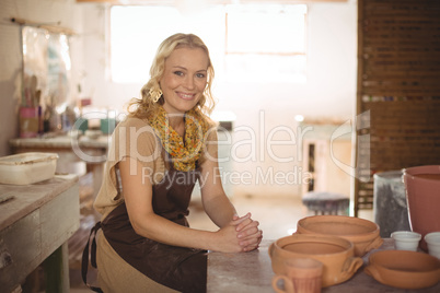 Portrait of female potter sitting at table