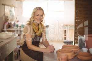 Portrait of female potter sitting at table