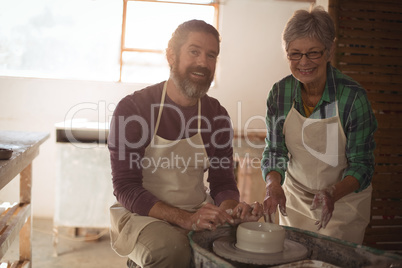 Male and female potter making a pot