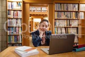 Young woman using laptop in library