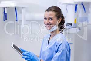 Smiling dental assistant using digital tablet