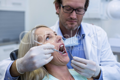 Dentist examining a woman with tools