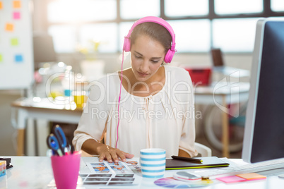 Graphic designer listening to music and looking at color swatch