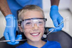 Dentist examining a young patient with tools