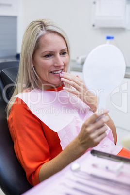 Patient checking her teeth in mirror