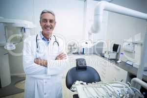 Portrait of confident dentist standing with arms crossed