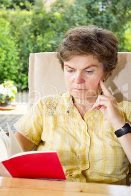 Woman sitting in the garden and reading