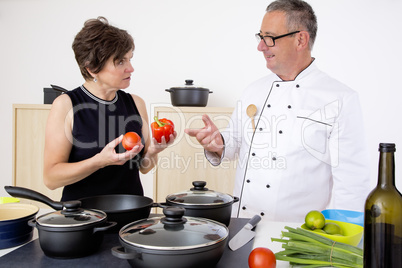 Elegant woman with Chef Cook in the kitchen