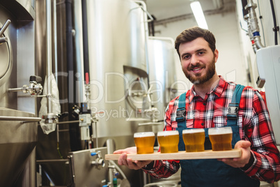 Manufacturer holding beer glasses in brewery