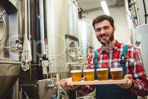 Manufacturer holding beer glasses in brewery