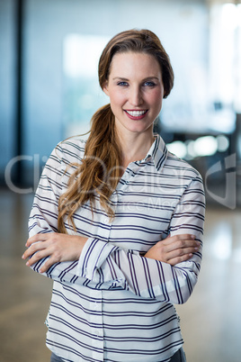 Woman standing with arms crossed in office Woman standing with arms crossed in office