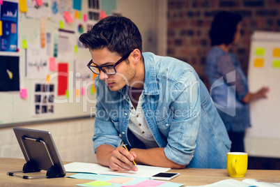 Business executive looking at digital tablet and taking notes in