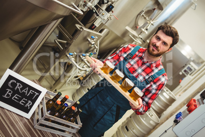 Portrait of manufacturer holding beer samples