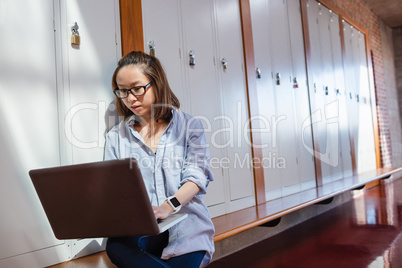 Young woman using laptop in locker room