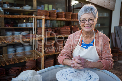 Female potter smiling in pottery workshop