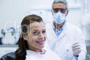 Smiling young patient sitting on dentist chair