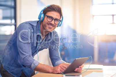 Business executive listening to music on digital tablet