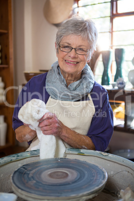 Female potter wiping her hand with napkin