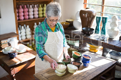 Female potter arranging bowl on worktop