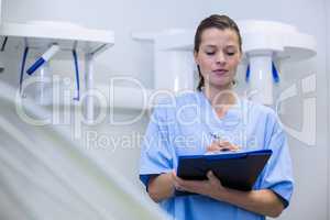 Dental assistant holding clipboard