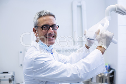 Portrait of a dentist adjusting light