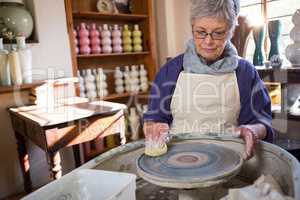Female potter cleaning pottery wheel