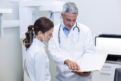 Dentist discussing report with female patient