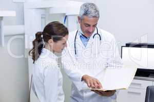 Dentist discussing report with female patient