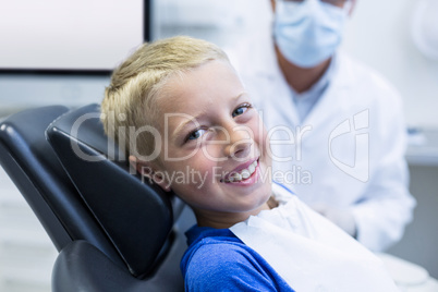 Smiling young patient sitting on dentist chair
