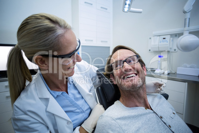 Female dentist interacting with male patient