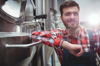 Confident manufacturer standing in brewery