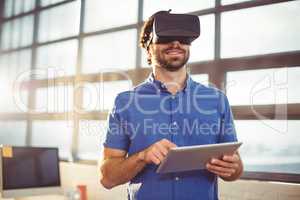 Male business executive in virtual reality headset using digital