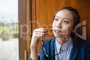 Thoughtful young woman looking through window