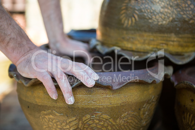 Close-up of male potter checking pot