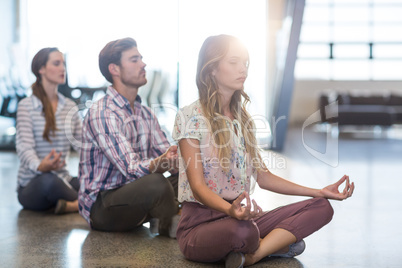 Business people performing yoga on floor