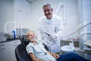 Dentist examining a young patient with tools