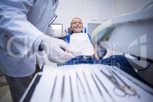 Dentist picking up dental tools to examine a young patient