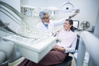 Smiling dentist talking to patient