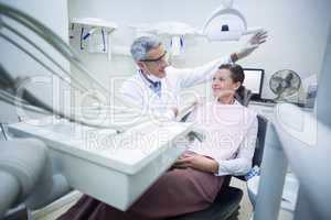 Smiling dentist talking to patient