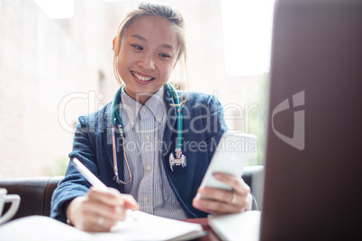 Female doctor using mobile phone