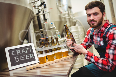 Portrait of manufacturer examining beer