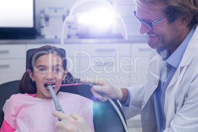 Dentist examining a young patient with tools