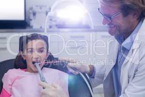 Dentist examining a young patient with tools