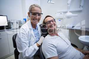 Female dentist and male patient smiling