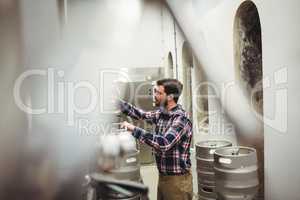 Manufacturer inspecting machineries in brewery